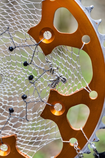 Photo black and orange dreamcatcher with motorcycle star made of feathers leather beads and ropes, hanging