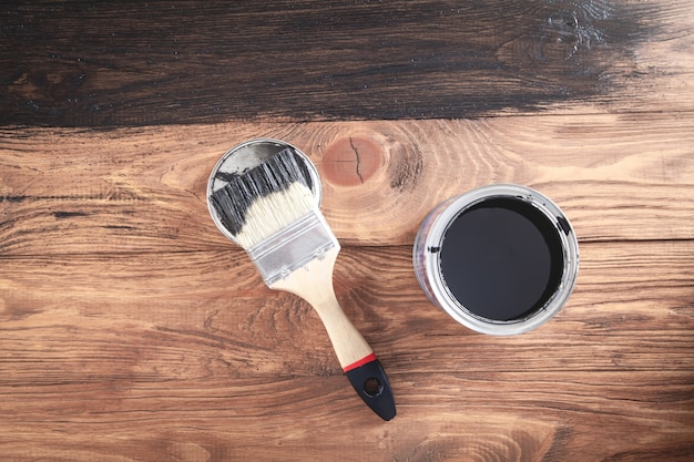 Black paint and brush on wooden background Painting wooden planks