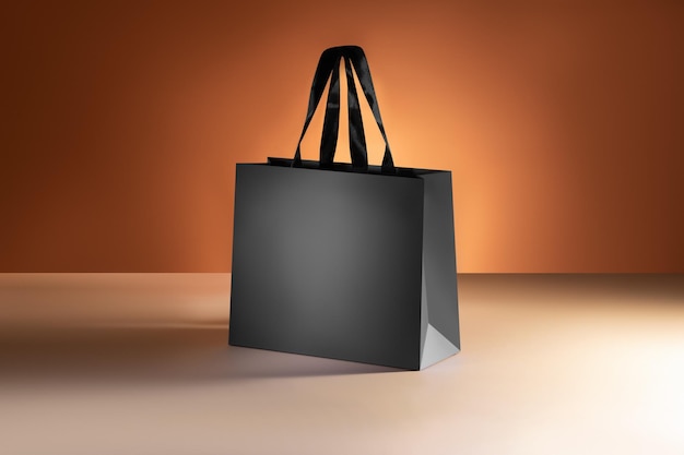 Black paper shopping bag mockup with black handles on colorful background