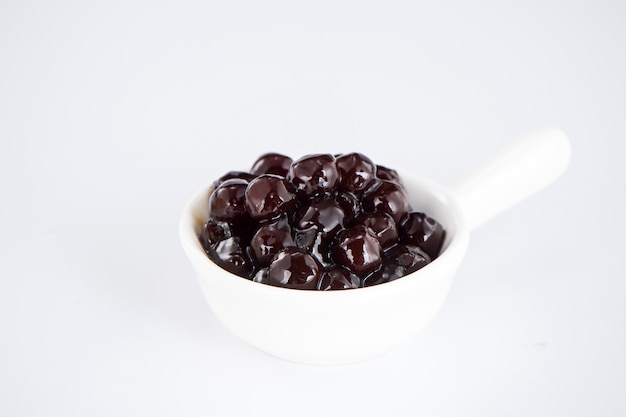 Black pearls. Boiled tapioca pearls for bubble tea on white background. Copy space