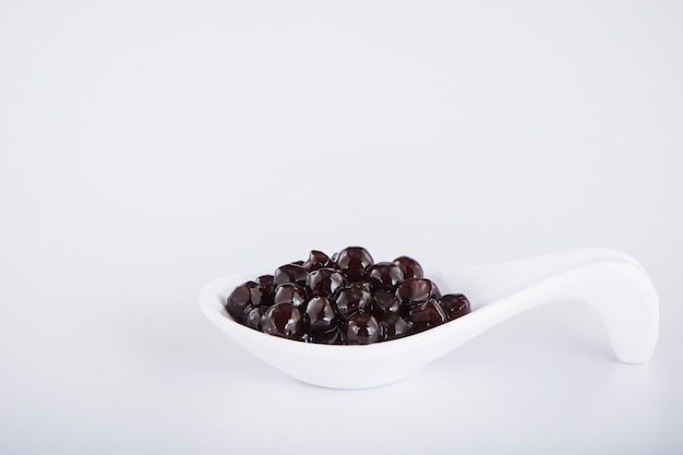 Black pearls. Boiled tapioca pearls for bubble tea on white background. Copy space