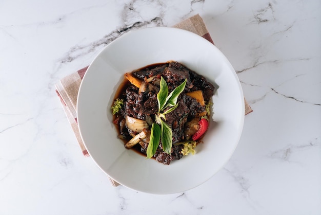 Black Pepper Beef with mushroom tomato onion in a dish isolated on mat top view on grey background