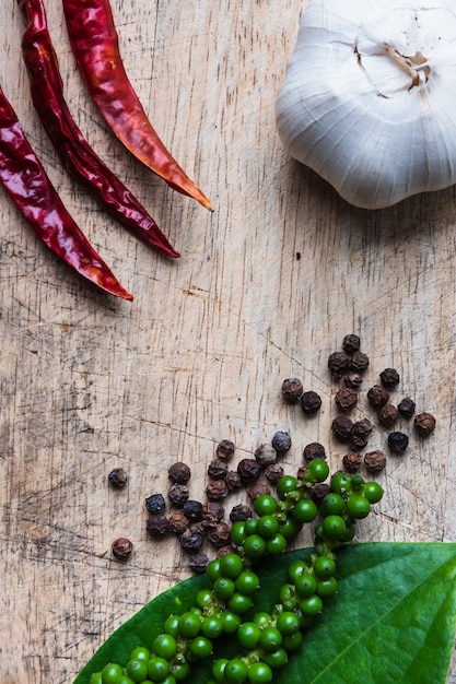  black pepper and green pepper near have garlic  and dried red chili or chilli cayenne