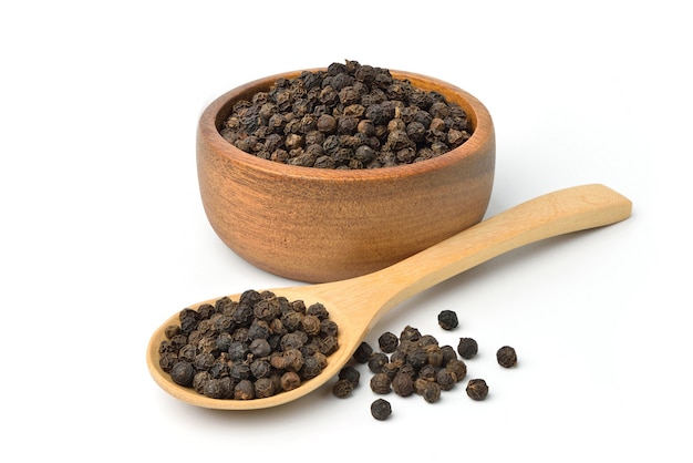 Black peppercorns in wooden bowl