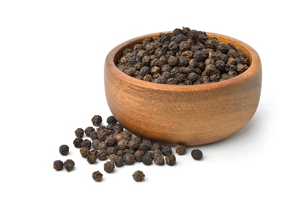 Black peppercorns in wooden bowl