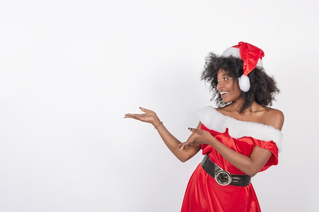 Black person in Santa Claus costume pointing with her arms