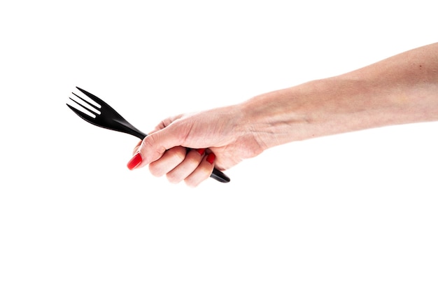 Black plastic fork in female hand isolated on white background