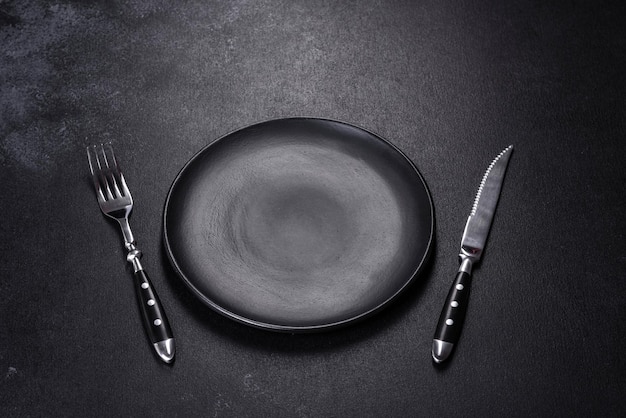 Black plate on a black background Flat lay top view copy space