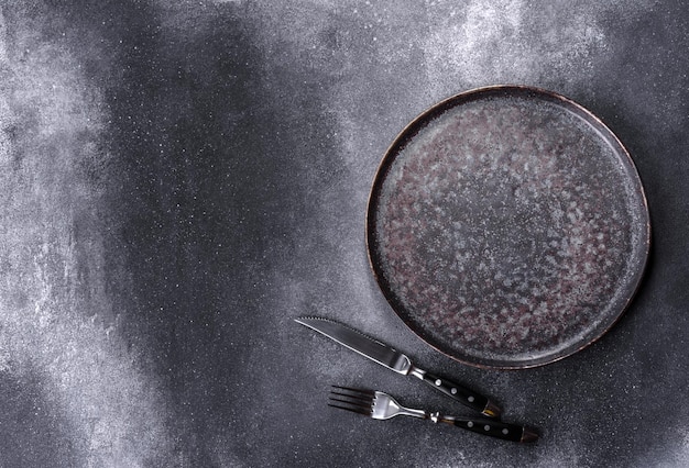 Black plate on a black background Flat lay top view copy space