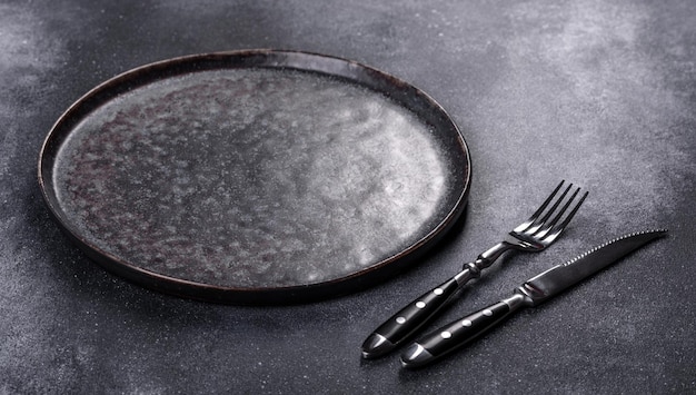 Black plate on a black background Flat lay top view copy space