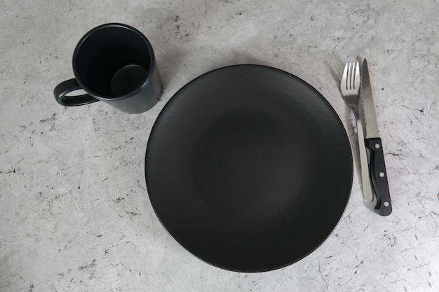 Black plate and black cup on a gray table