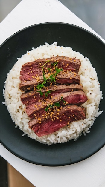 Photo black plate with beef with rice isolated on transparent background top view asian cuisine