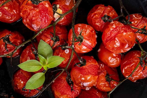 Photo black plate with confit tomatoes.