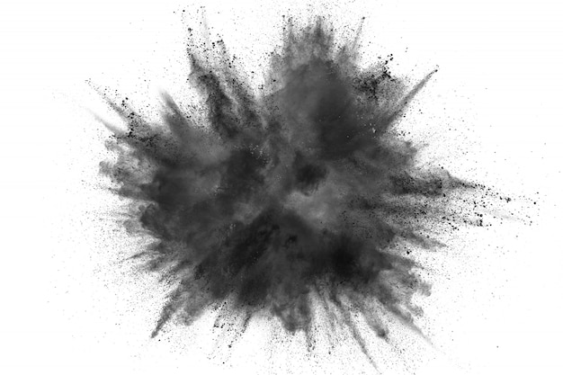 Black powder explosion against white background. Charcoal dust particles exhale in the air.