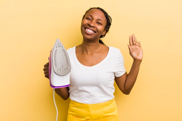 Black pretty woman smiling happily waving hand welcoming and greeting you