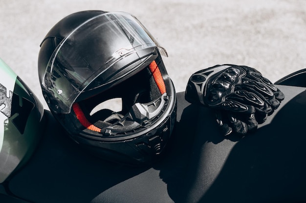 Black protective gloves for a motobiker with plastic inserts and a black helmet