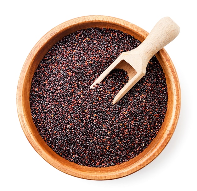 Black quinoa in a plate with a scoop closeup on a white background isolated Top view