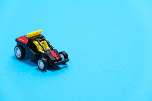 A black racing toy car on a blue background