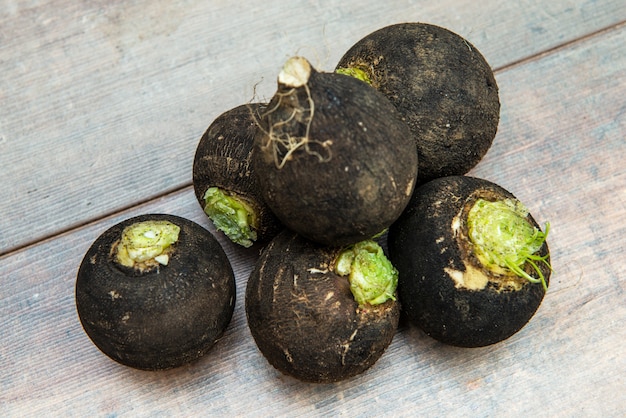 Black radish on the wooden surface