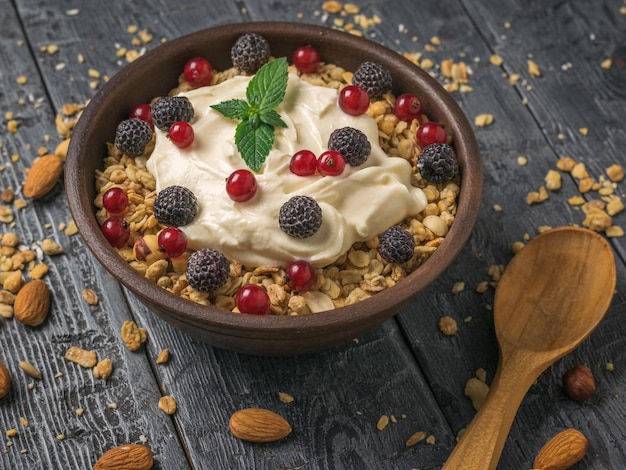 Black raspberries and red currants in a bowl with granola and yogurt