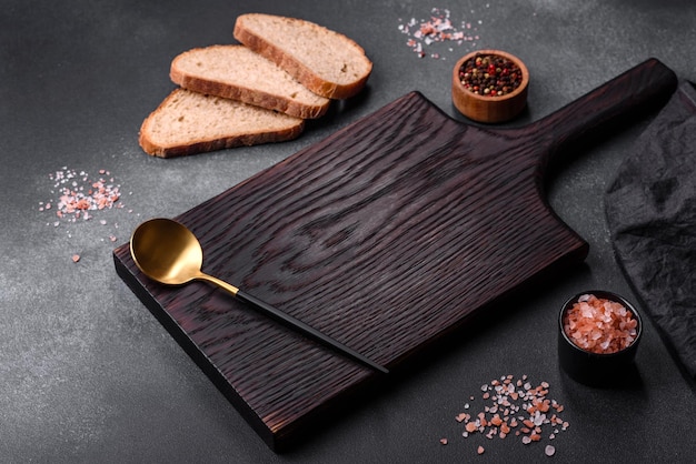 Black rectangular wooden cutting board with salt and spices