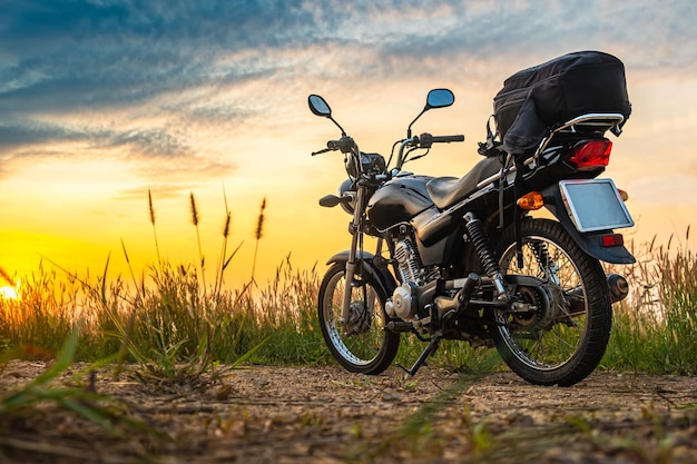 Black retro motorcycle with backpack parked outdoors