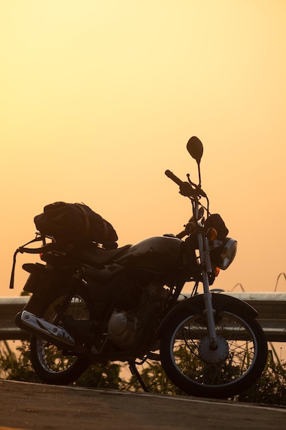 Black retro motorcycle with backpack parked outdoors