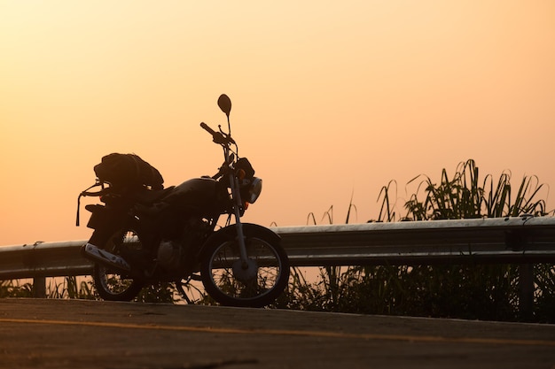 Black retro motorcycle with backpack parked outdoors