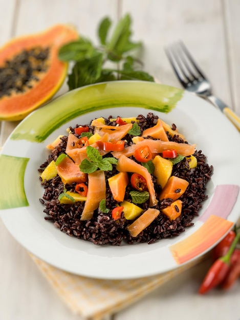 Black rice with papaya and smoked salmon selective focus