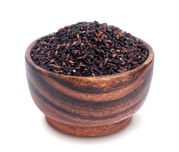 Black rice in wooden bowl isolated on white background