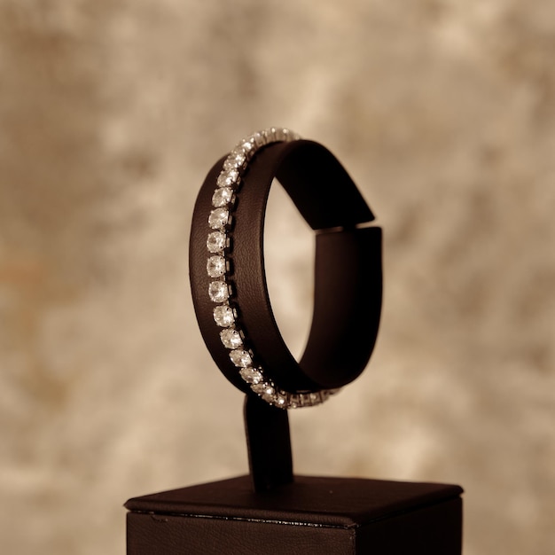 A black ring with diamonds is on a black box.