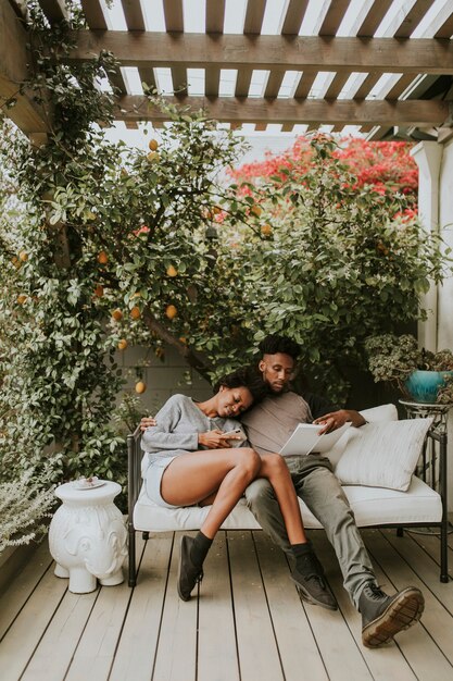 Photo black romantic couple chilling in the garden with a book