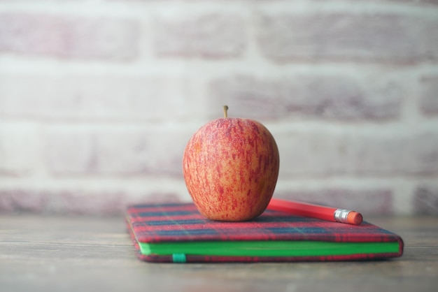 Black to school concept with apple on notepad on table