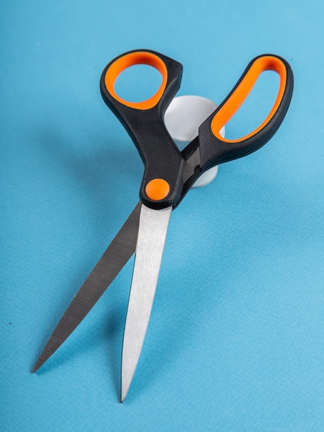 Black scissors isolated on blue background