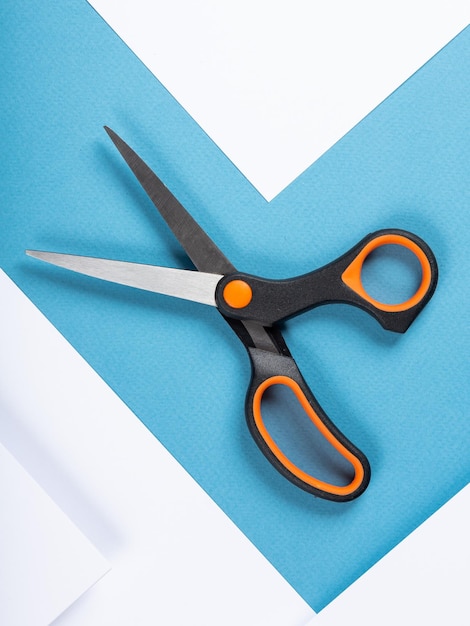 Black scissors isolated on white and blue background