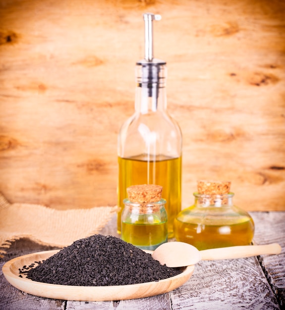 The black sesame and oil on old wooden background