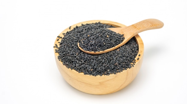 Black sesame seeds in a spoon and bowl