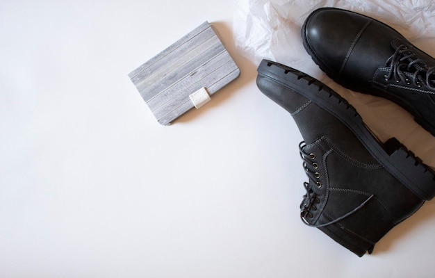 Black shoes next to a notebook minimal flat lay