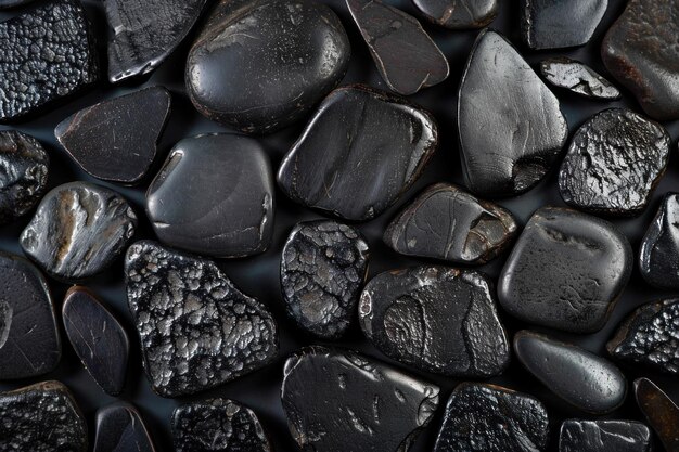 Photo black shungite elite stones forming a background covering the whole surface