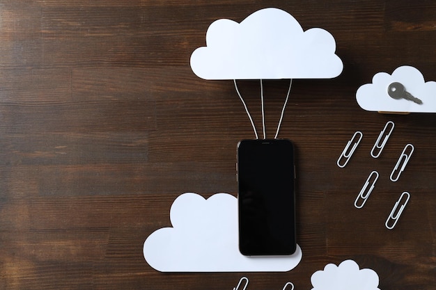 Black smartphone with a paper cloud on a dark background