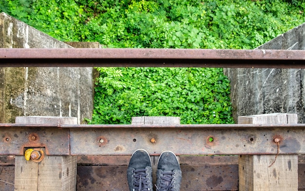 Black sneaker on wooden old railroad