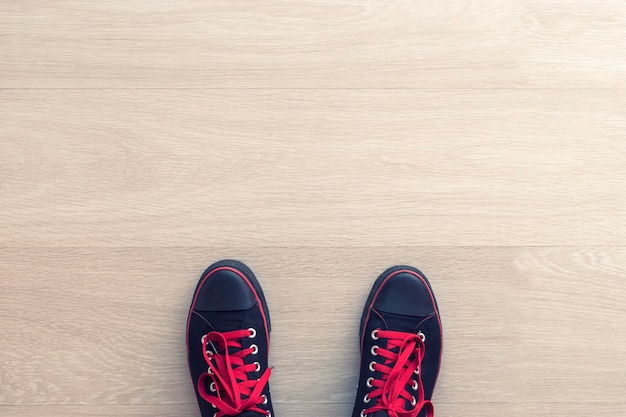 Black sneakers on wooden white floor