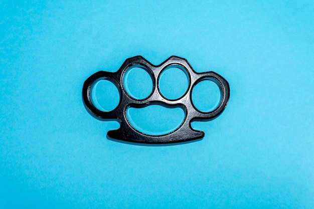 Black Steel brass knuckles blue background hooligan fight fighting without rules street banditry