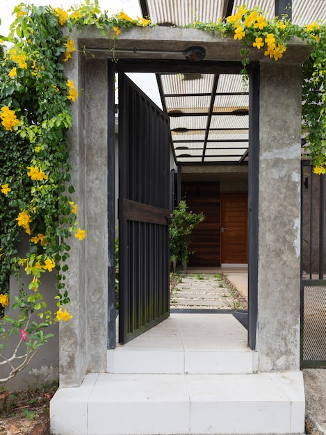 Black stell door fence entrance to home with cement block and white stones walkway 