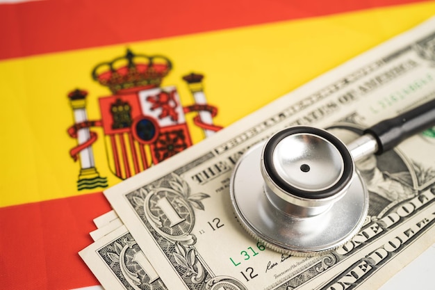 Black stethoscope with US dollar banknotes on Spain flag background Business and finance concept