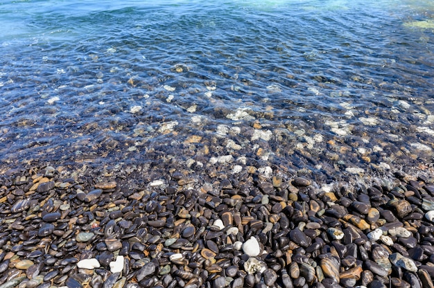 Black stone natural in tropical sea on coastline