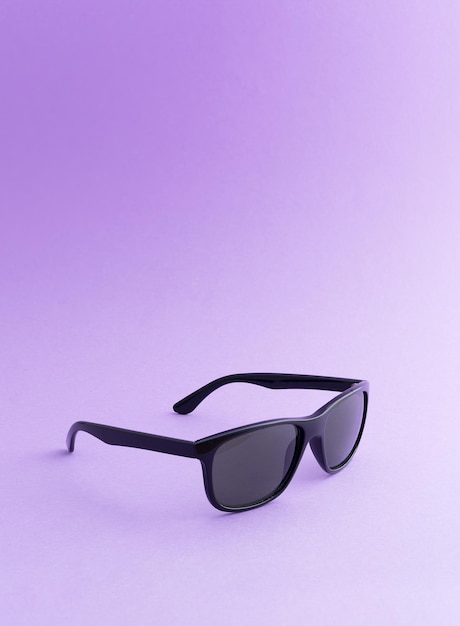 Black sunglasses over purple background