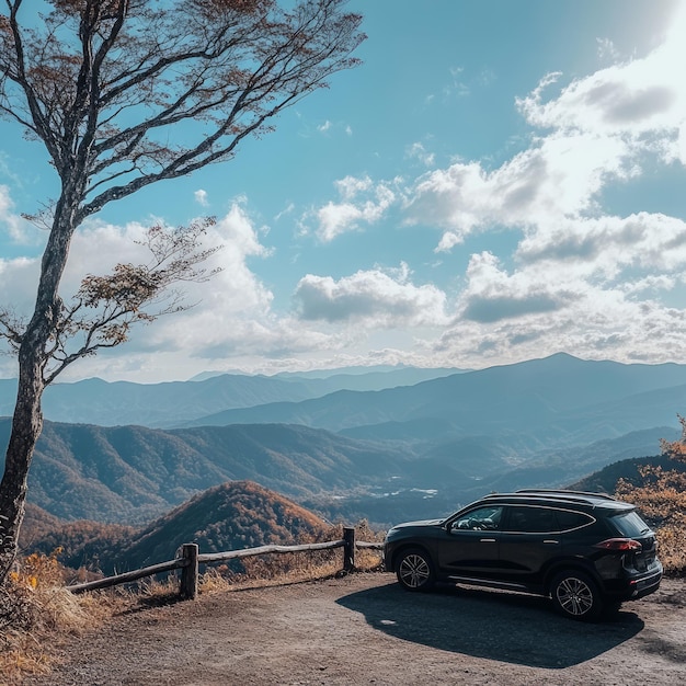 A black SUV parked on a mountain overlook with a view of distant mountains blue sky and white clouds