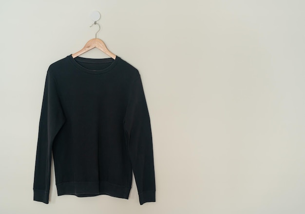 Black sweater hanging on hanger