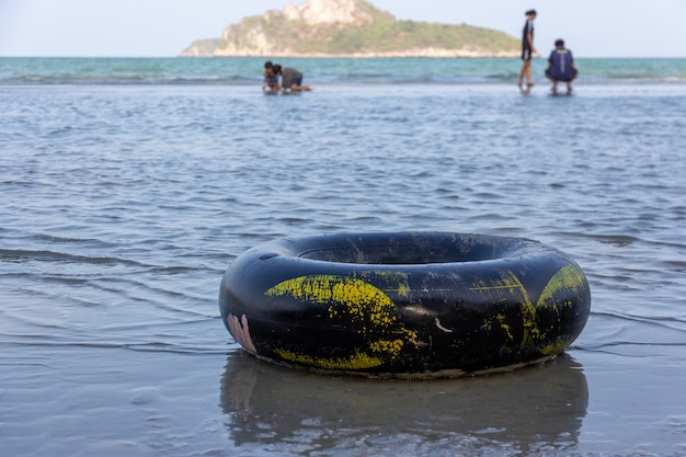 A black swim ring on a sandy ocean beach